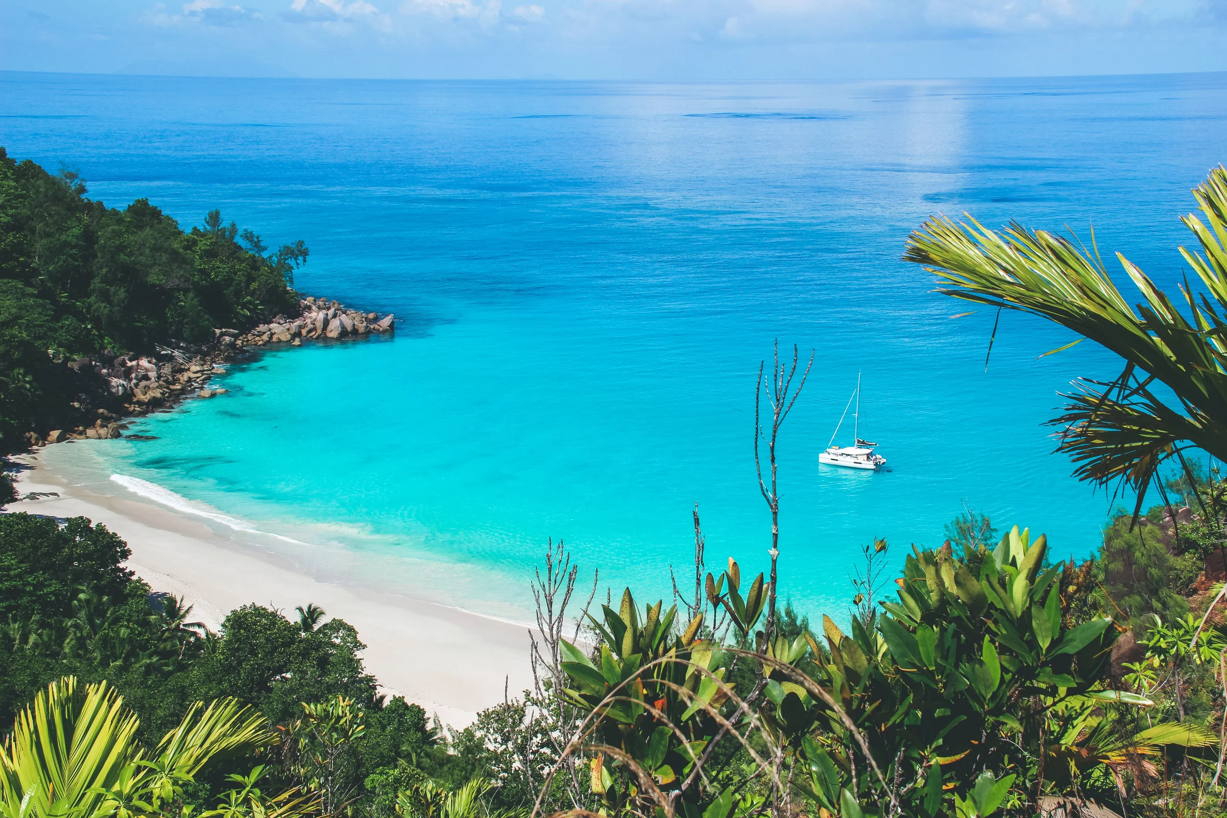 Turquoise cove with a moored sailboat